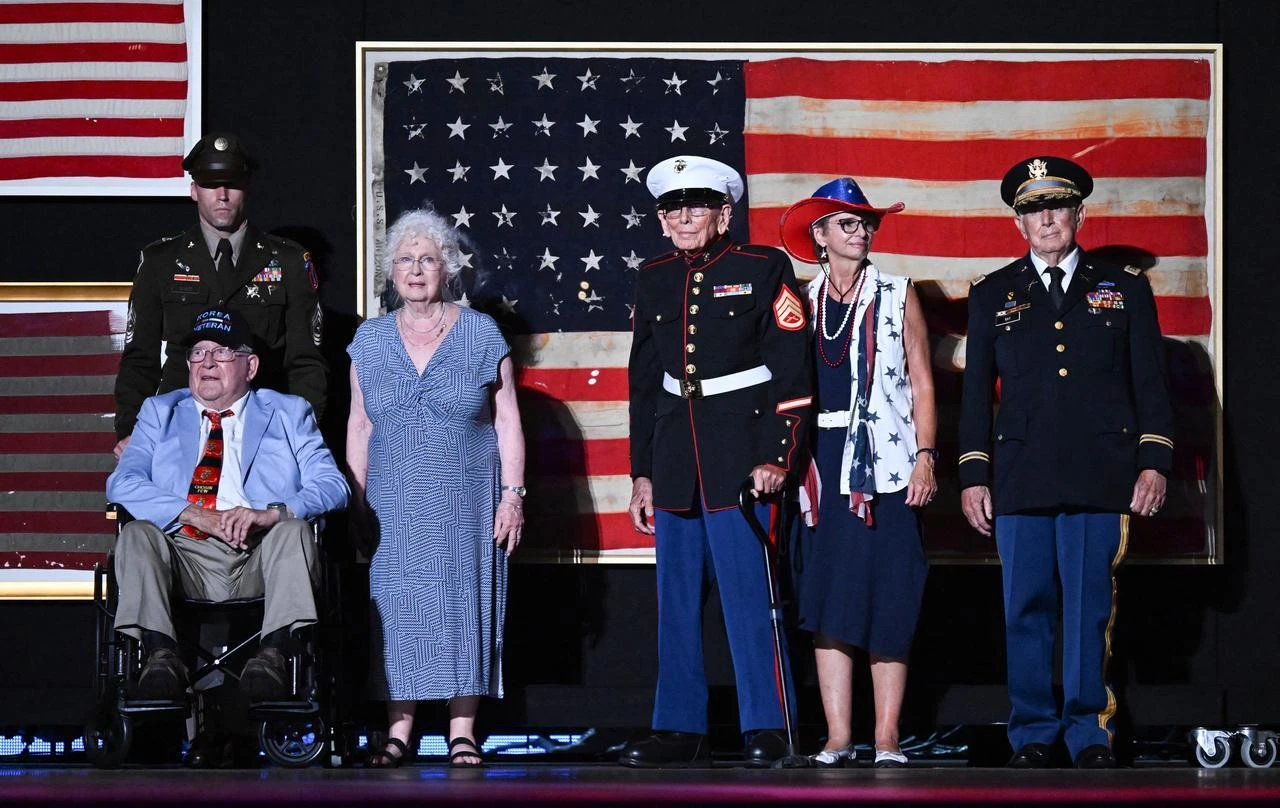 Retired US Marine Corps veteran Patrick Finn (L), retired Marine Private First Class Rudy Meekins (C) with their families appear on stage as US President Donald Trump (off frame) speaks during the "Salute to America" Independence Day celebration in Washington, DC, July 4, 2026. (AFP Photo)