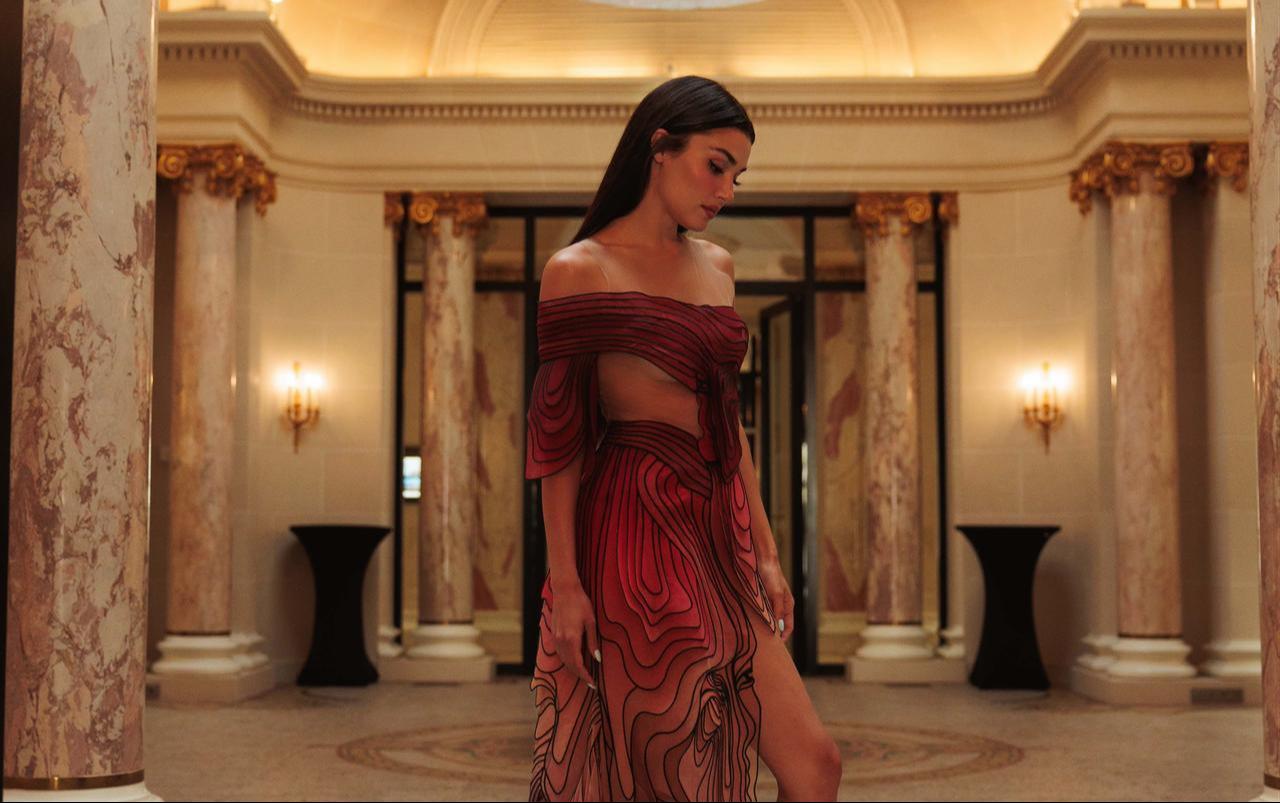Turkish actress Hande Ercel poses in a red-and-black illusion-style dress during Paris Fashion Week, July 6, 2026. (Photo via Instagram/@handemiyy)