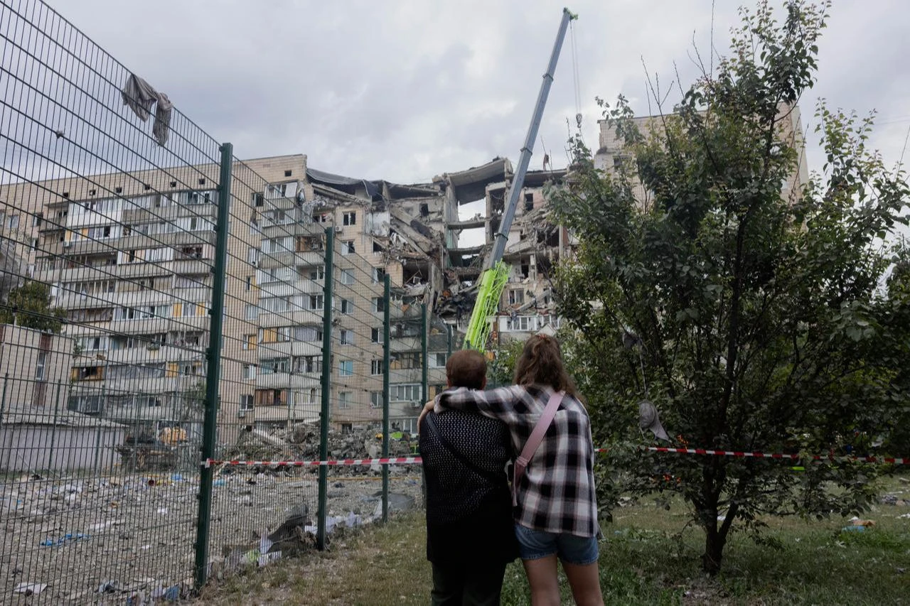 Local residents stand near a damaged residential building following a Russian missile strike on the Ukrainian capital of Kyiv on July 6, 2026. (AFP Photo)