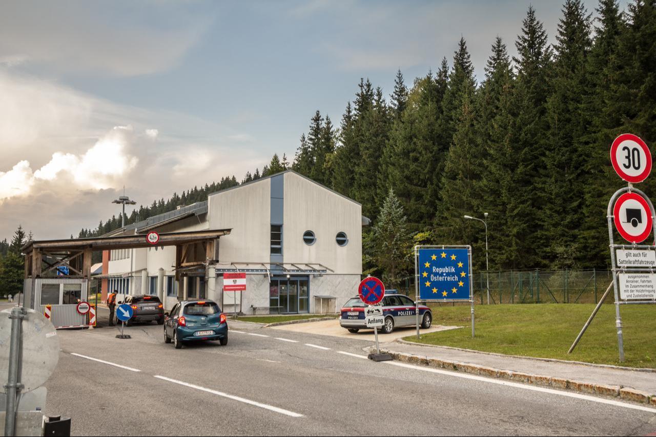 Austrian police car controlling border crossing with an EU border sign in front.  (Adobe Stock Photo)
