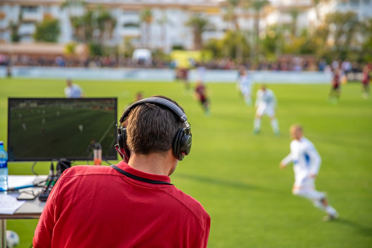 A football commentator describes the game live on TV and radio. (Adobe Stock Photo)