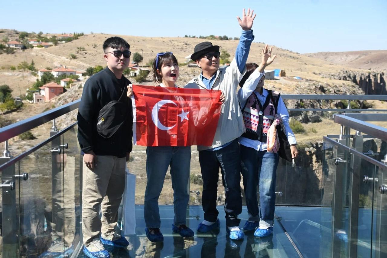 Tourists pose with a Turkish flag on the Ihlara Glass Terrace overlooking Ihlara Valley in Aksaray, Türkiye. (AA Photo)