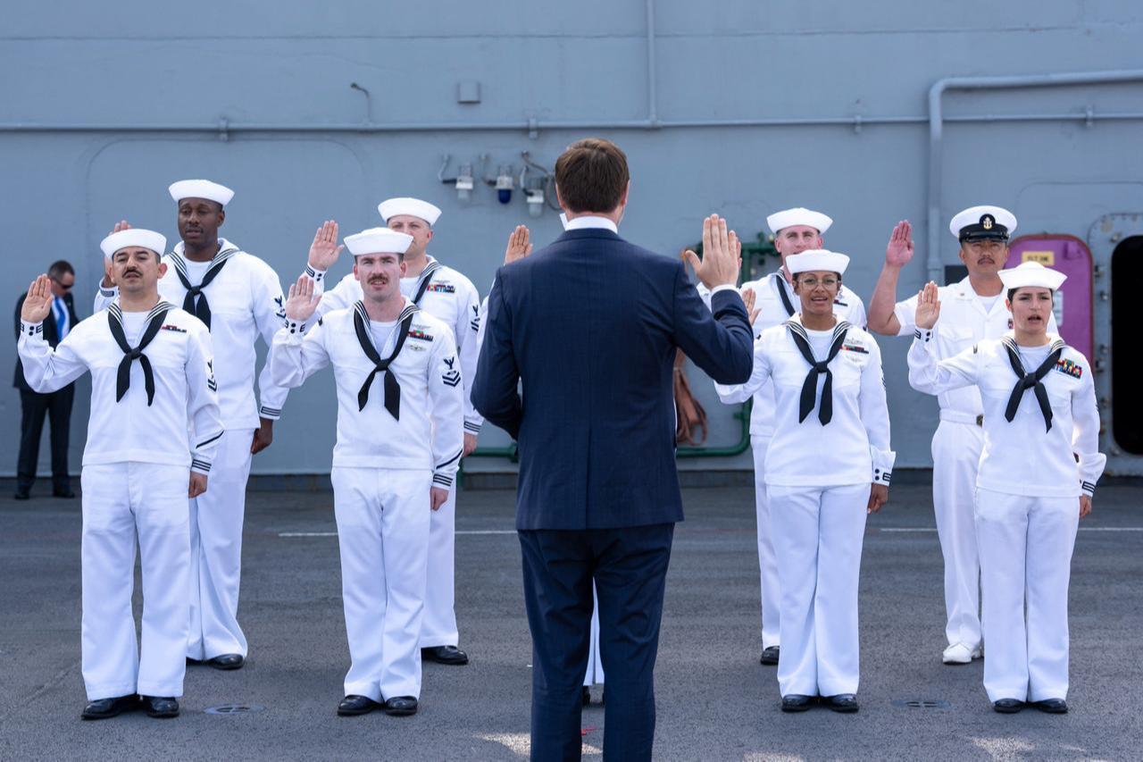 This image shows Vice President JD Vance swearing in reenlisted U.S. Navy midshipmen to celebrate America's 250th birthday.