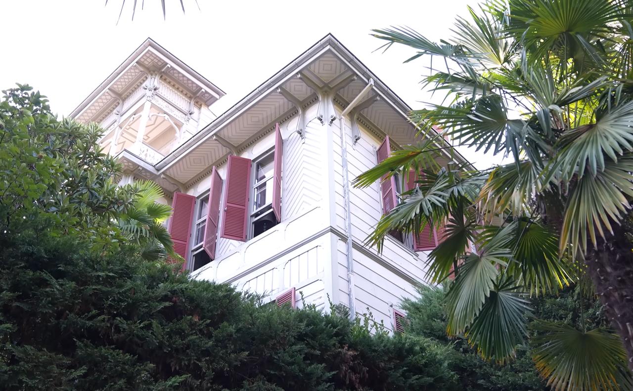 The wooden facade of Nevbahar Koc’s historic Bosphorus yali, surrounded by greenery in Istanbul, Türkiye. (Photo via YouTube/@Homeworthy)