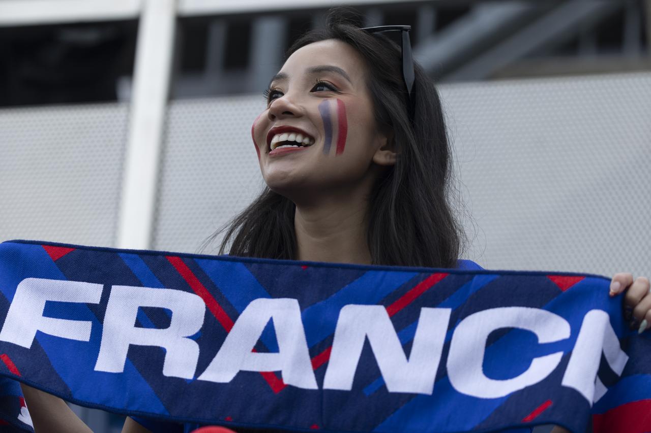Female football fan cheering with banner that says 'France'. (AA Photo)