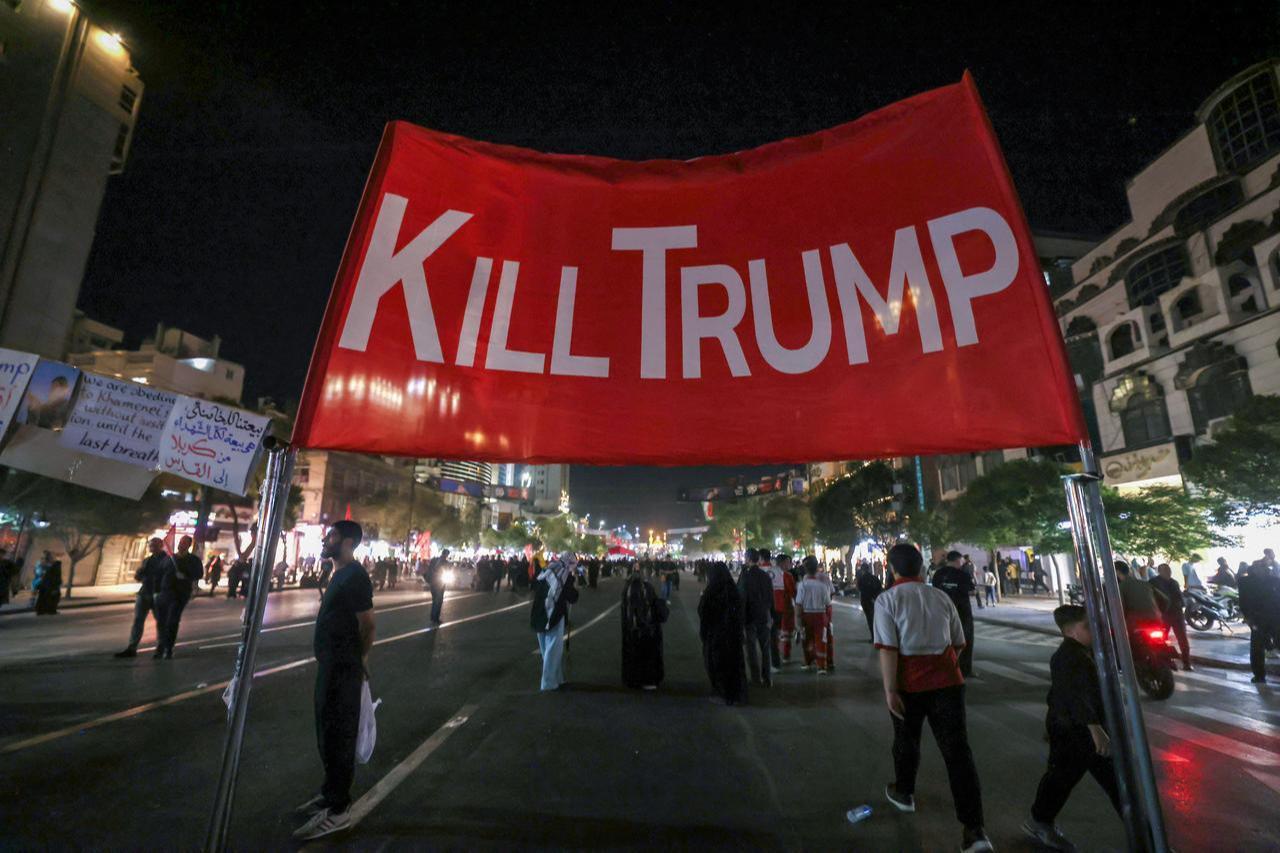 Mourners walk past an anti-US banner as they arrive to attend the funeral of slain Iranian leader Ali Khamenei in Mashhad early, July 9, 2026. (AFP Photo)