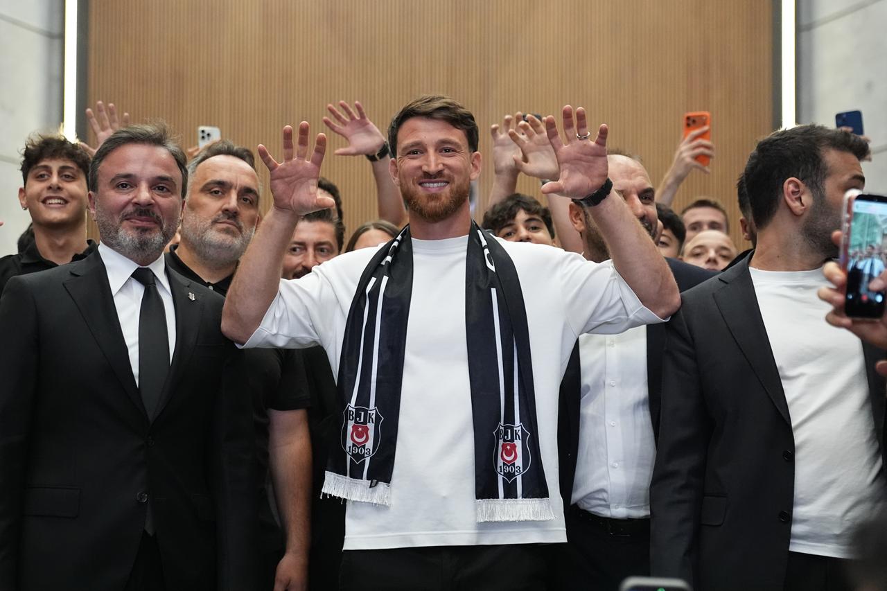 Salih Ozcan poses with a Besiktas scarf as supporters welcome him at Istanbul Airport following the club’s principle agreement, Istanbul, Türkiye, July 8, 2026. (AA Photo)