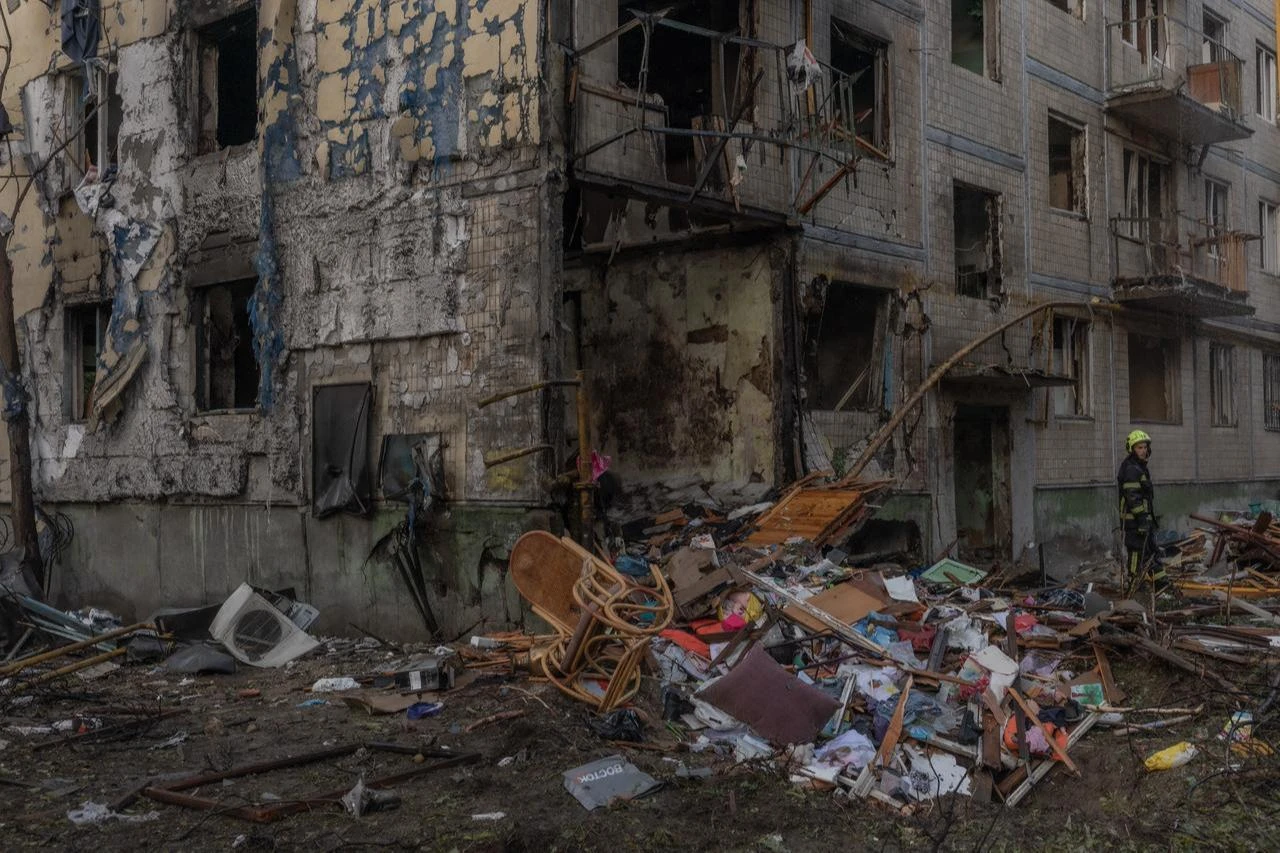 A rescuer works outside a multi-story residential building damaged in a Russian air attack on Kyiv on August 1, 2026. (AFP Photo)