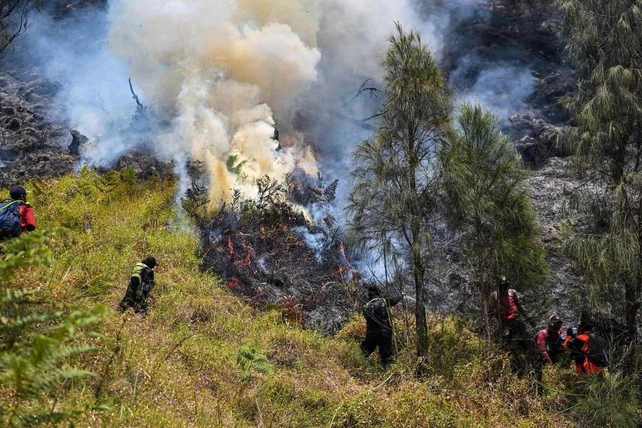 Firefighters work to contain a wildfire spreading across a forested hillside in Indonesia, Aug. 6, 2026. (AFP Photo)