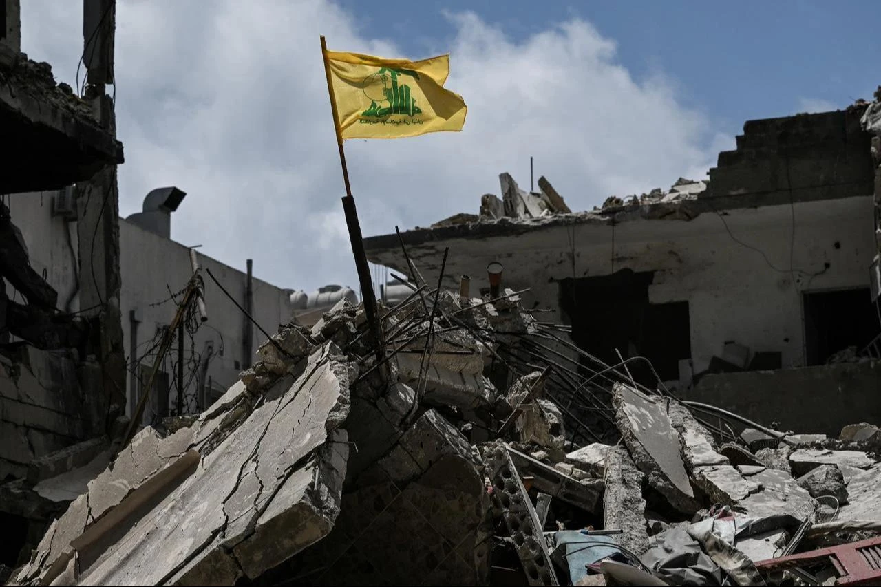 A yellow flag belonging to Hezbollah flutters on top of the rubble of a building in the southern Lebanese coastal city of Tyre, June 23, 2026. (AFP Photo)