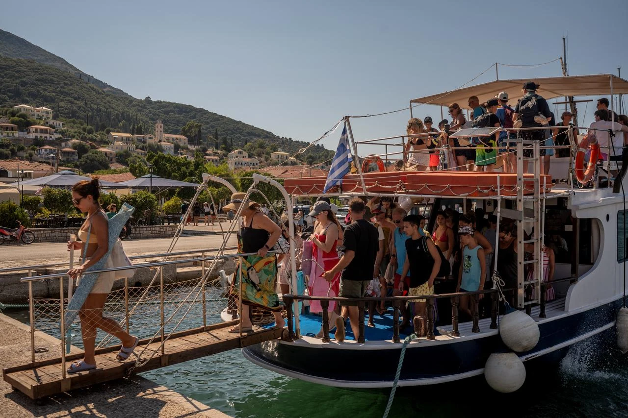 Tourists disembark from a boat after returning from nearby beaches on the island of Ithaca, in the Ionian Sea, on August 3, 2026. (AFP Photo)