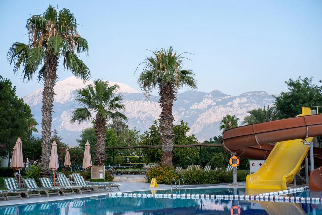 A swimming pool surrounded by palm trees at a hotel in southern Türkiye. (Adobe Stock Photo)