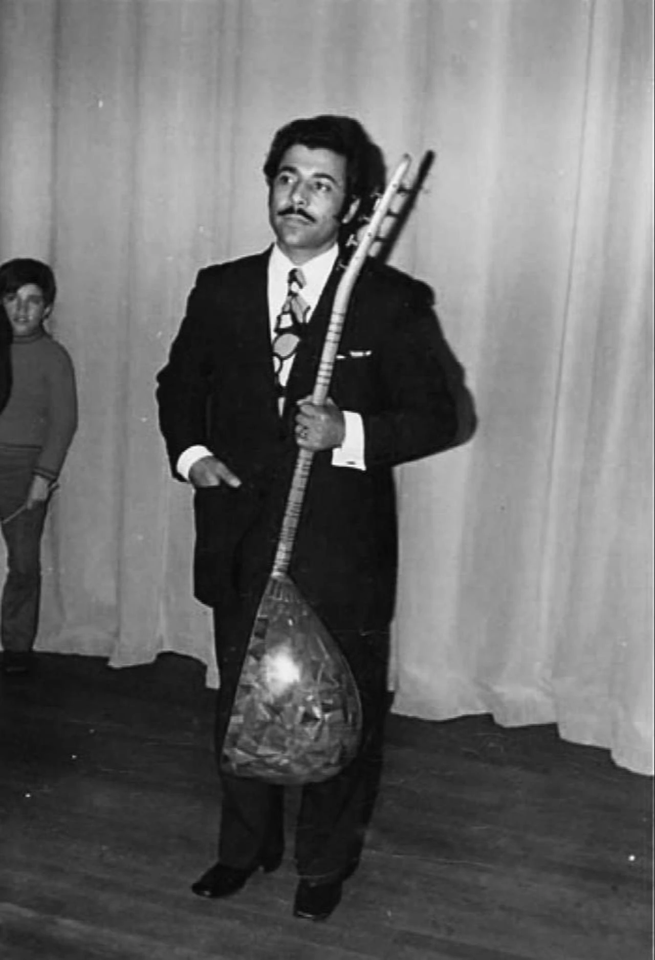 A young Neset Ertas poses with his saz in an archival photograph. (Photo via Türkiye Ministry of Culture and Tourism)