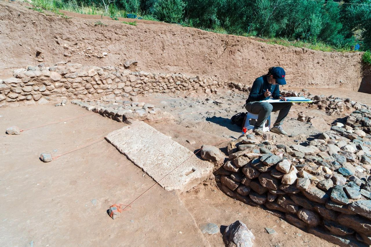 An archaeologist documents architectural remains uncovered during excavations at the ancient city of Sardis in Manisa, western Türkiye. (IHA Photo)