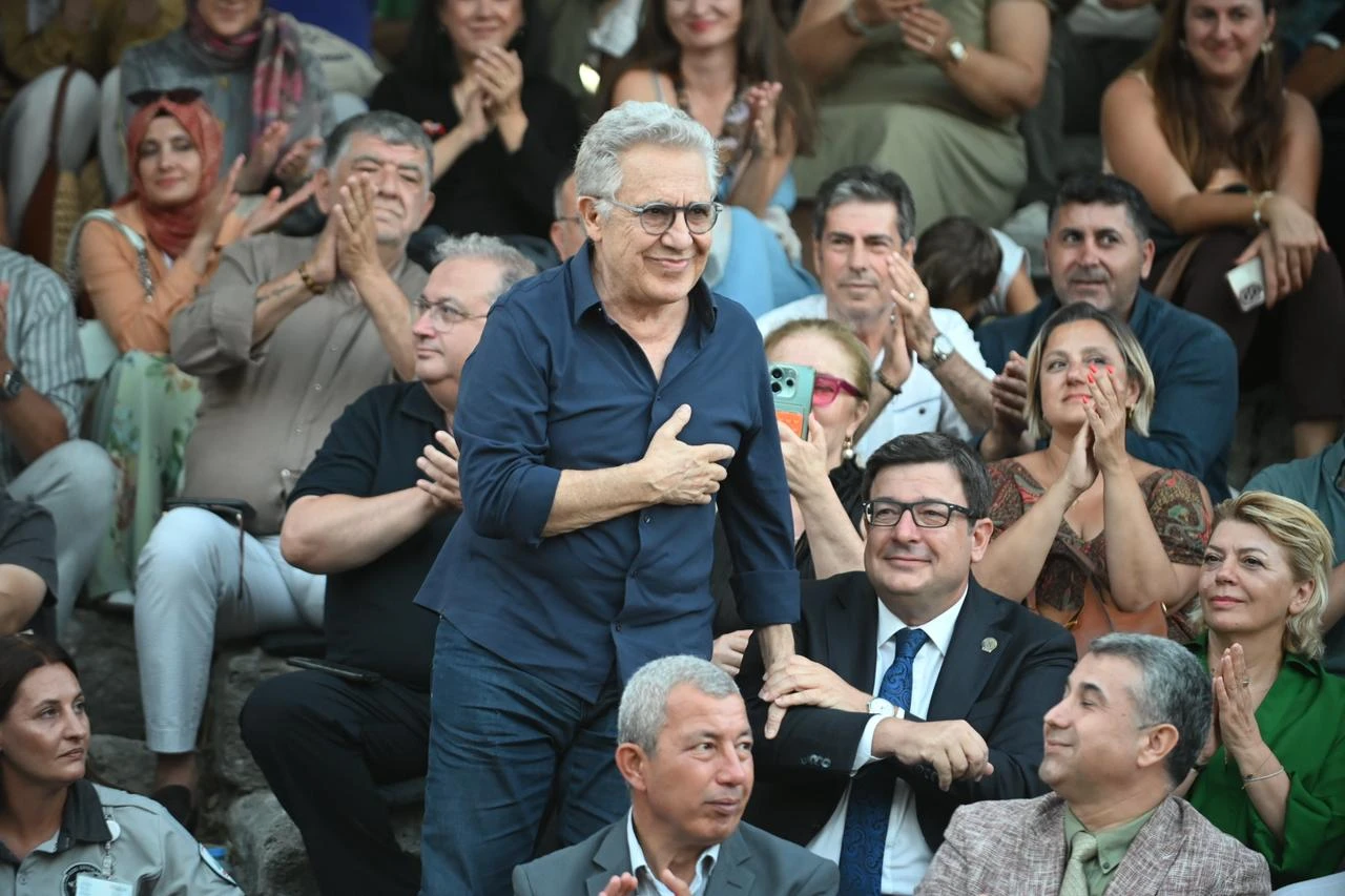 Turkish musician and writer Zulfu Livaneli receives applause during the official opening of the 63rd International Troia Festival at the ancient city of Troy in Canakkale, Türkiye, Aug. 10, 2026. (AA Photo)