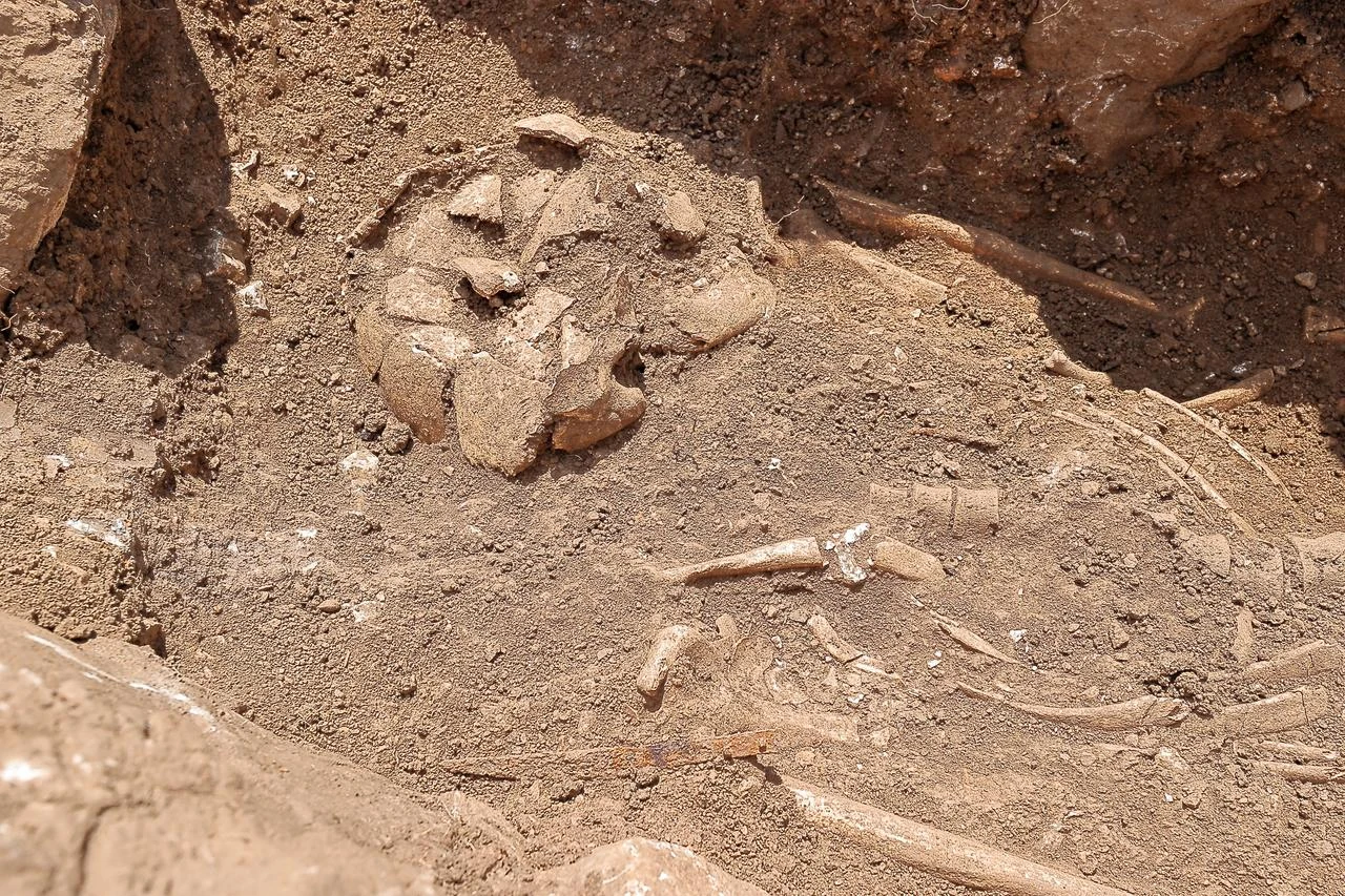 A partially uncovered skeleton is seen inside a roughly 2,300-year-old tomb discovered during excavations at Hattusa. (AA Photo)