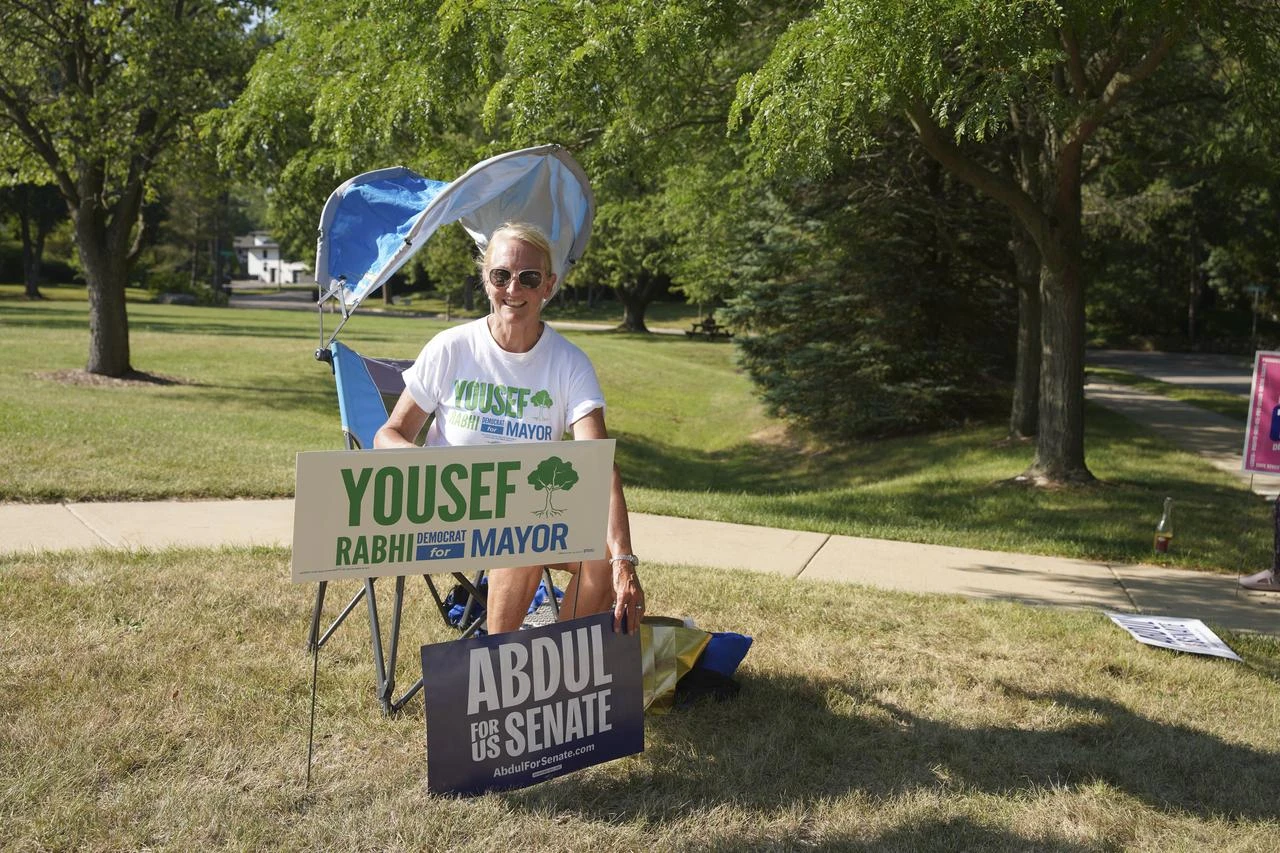 A volunteer displays her signs for political candidates outside of a polling place in Ann Arbor, MI, United States on August 4, 2026. (AA Photo)
