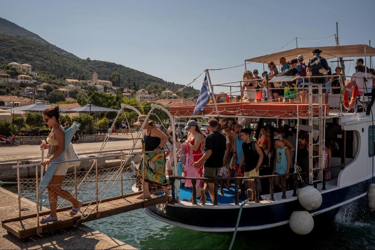 Tourists disembark from a boat after returning from nearby beaches on the island of Ithaca, in the Ionian Sea, on August 3, 2026. (AFP Photo)
