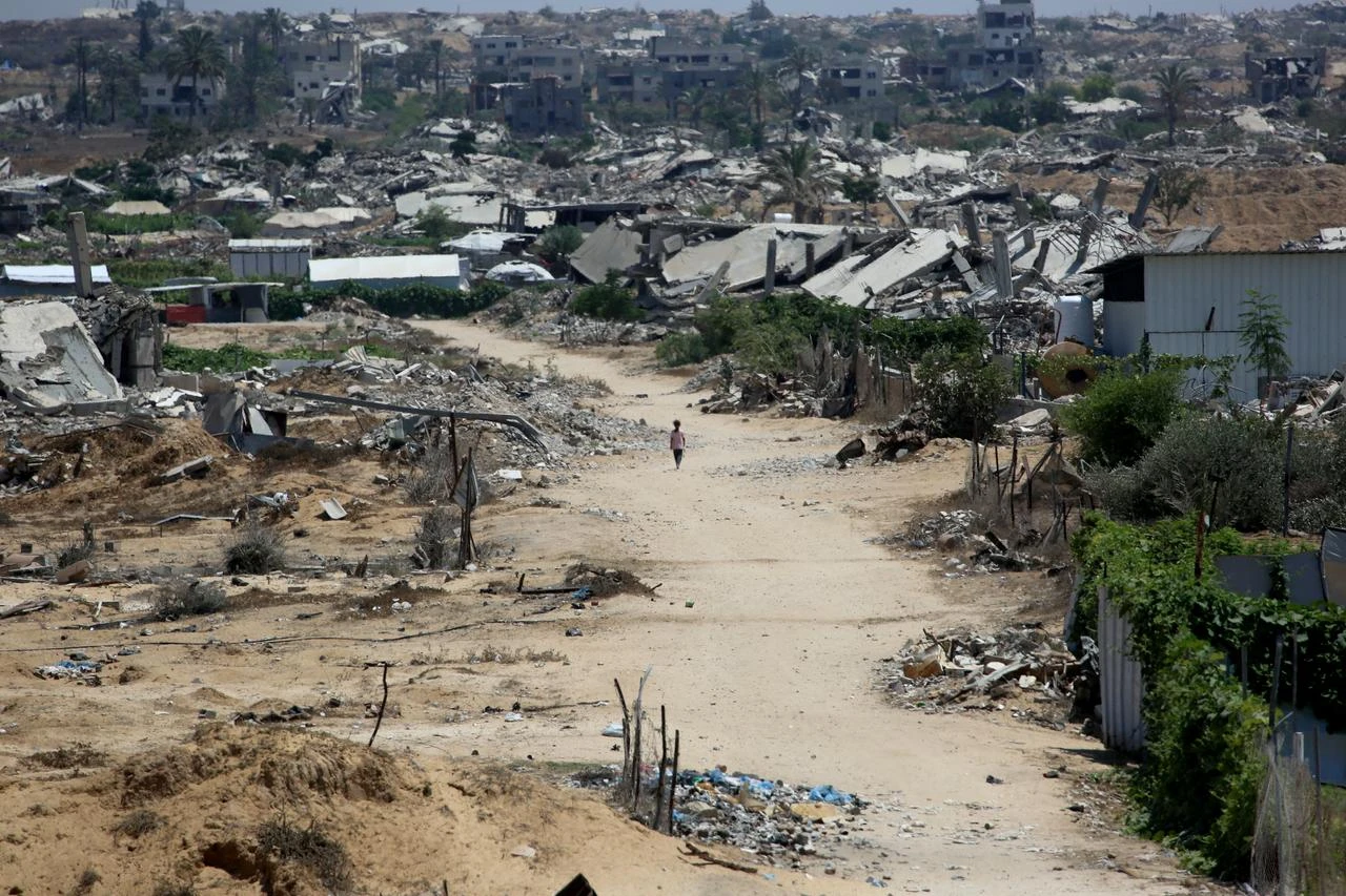 An internally displaced Palestinian child walks past the rubble of buildings and home destroyed by the Israeli military, in Khan Yunis southern Gaza Strip, August 11, 2026. (AFP Photo)