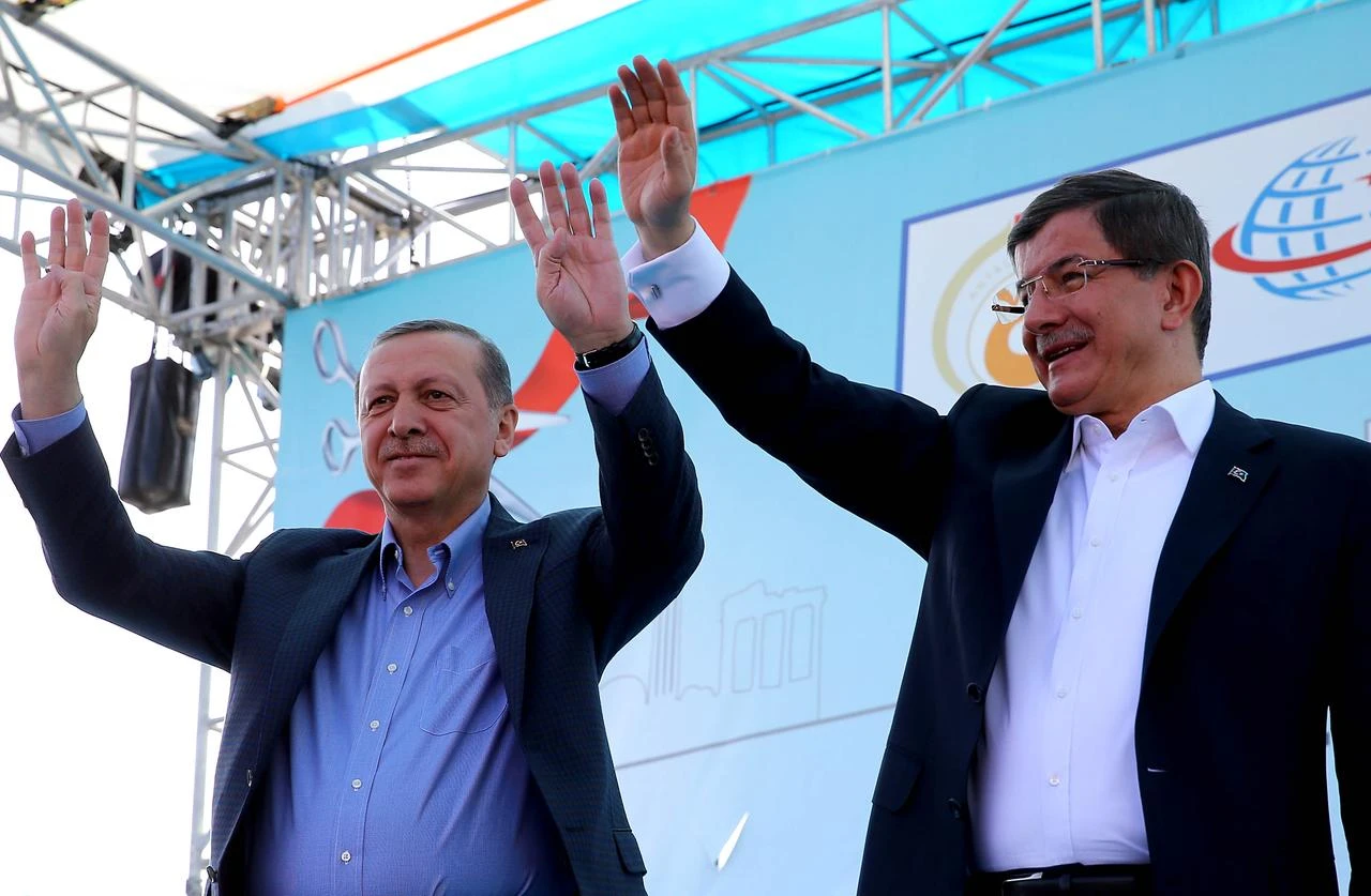 Turkish President Recep Tayyip Erdogan (L) raises his hands with the Rabia gestures as Prime Minister Ahmet Davutoglu (R) waves his hands during an opening ceremony in Kepez district of Antalya, Türkiye on April 22, 2016. (AA Photo)