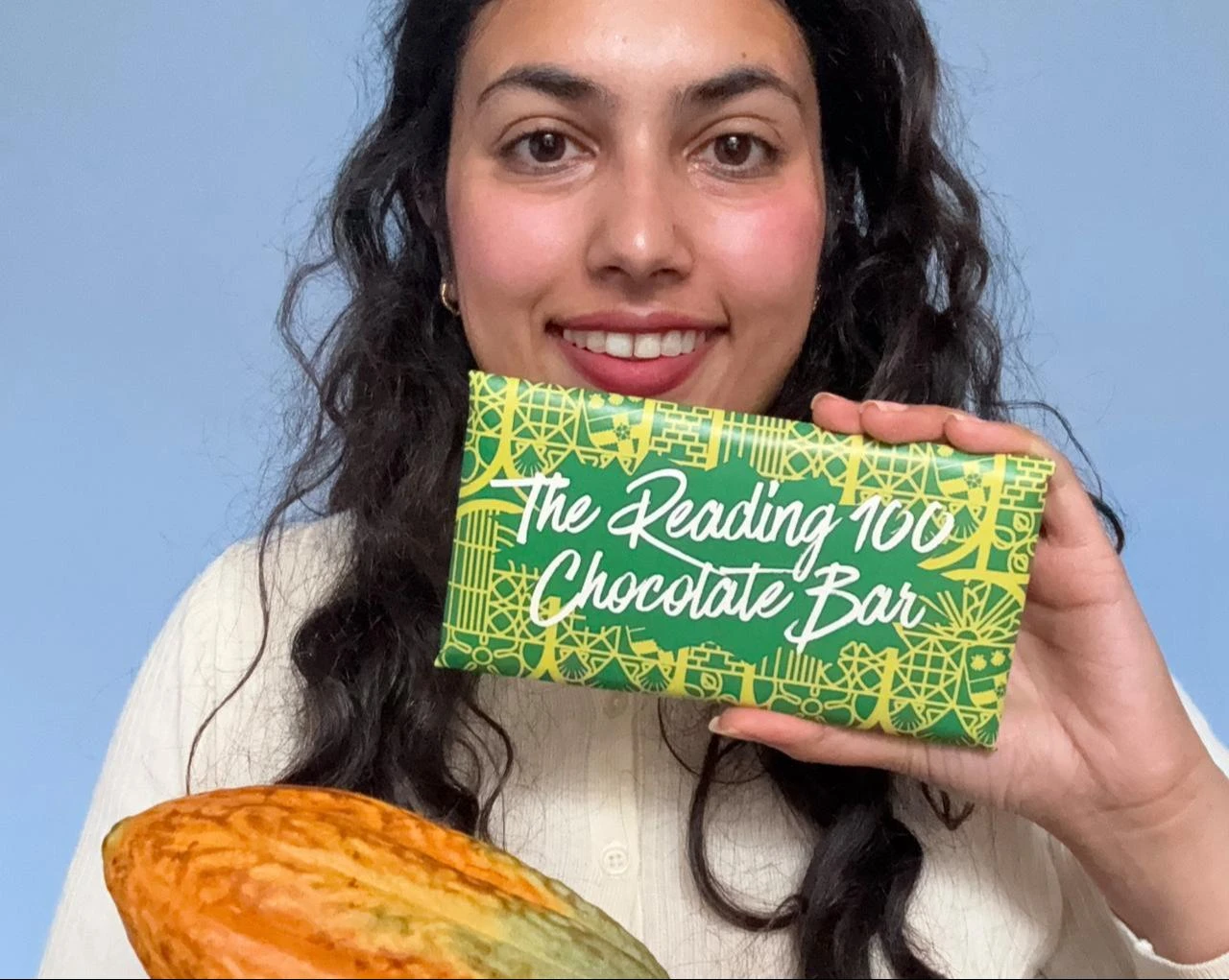 Food security master's student Maha Khan holds the Reading 100 Chocolate Bar alongside a cocoa pod at the University of Reading in Berkshire, U.K. (Photo via University of Reading)