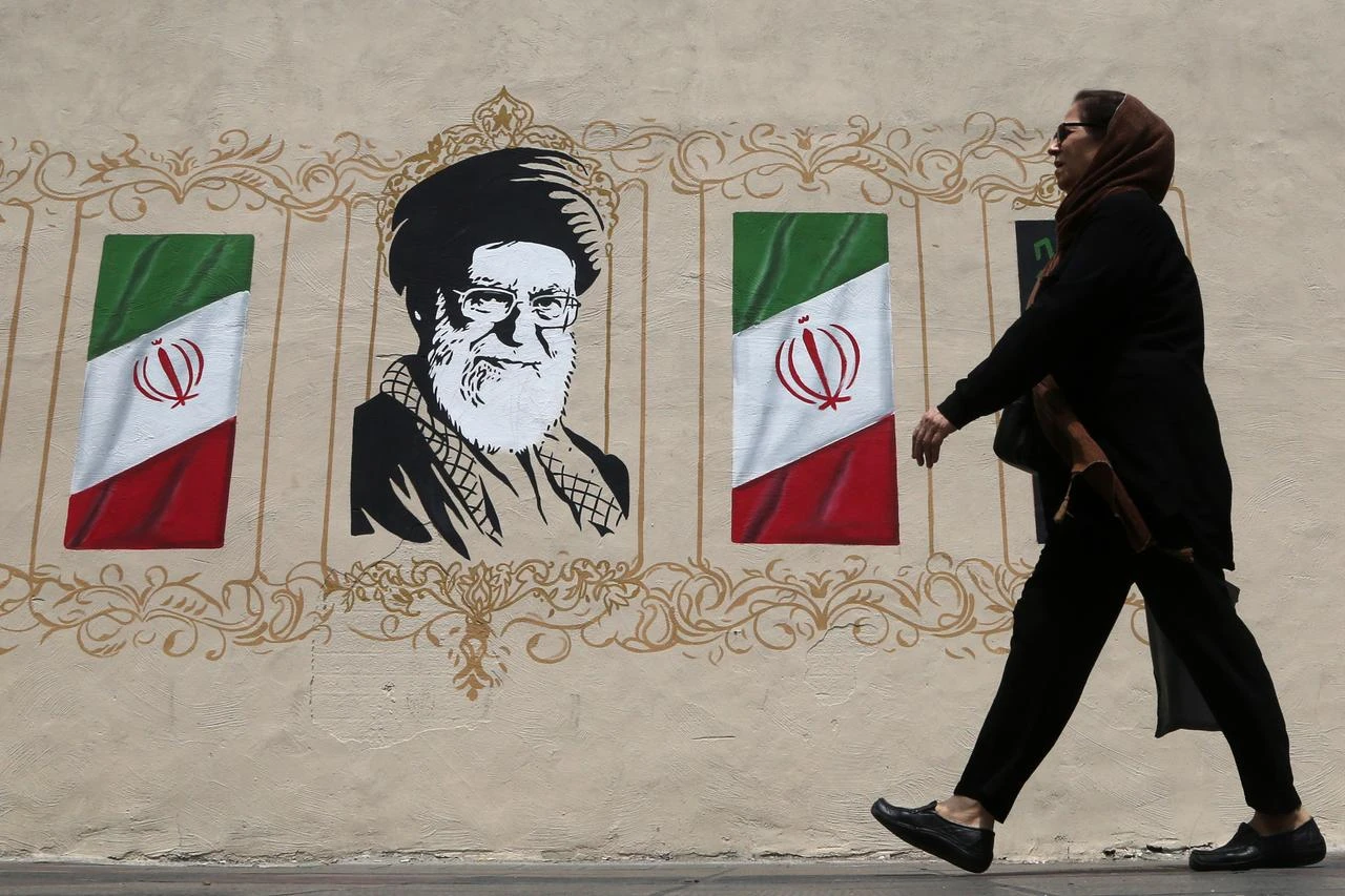 A woman walks in front of a wall mural as daily life continues amid ongoing tensions between the United States in Tehran, Iran, on August 6, 2026. (AA Photo)