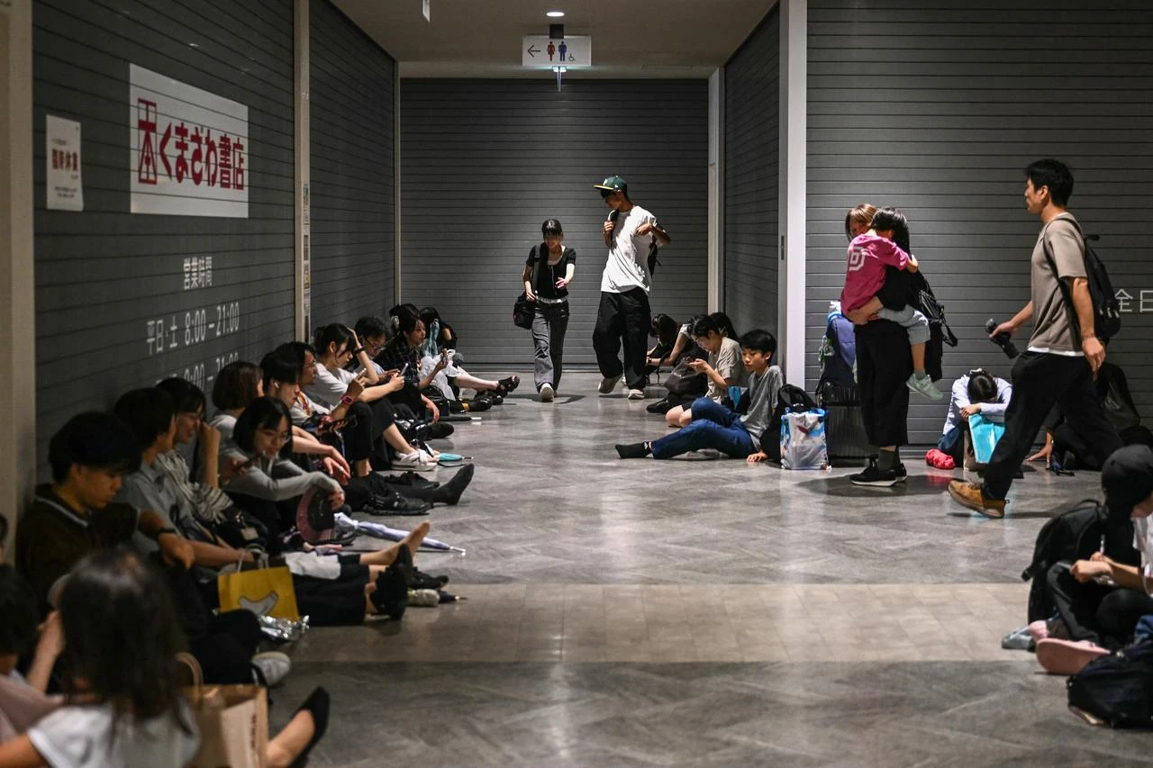 Stranded passengers rest on the floor at the shopping mall at Chiba Metro Station in Chiba on August 13, 2026. (AFP Photo)