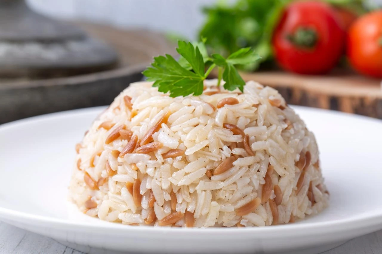 Rice pilaf topped with shredded chicken and chickpeas, molded into the traditional dome and flipped onto the plate — a familiar comfort food in Türkiye. (Adobe Stock Photo)