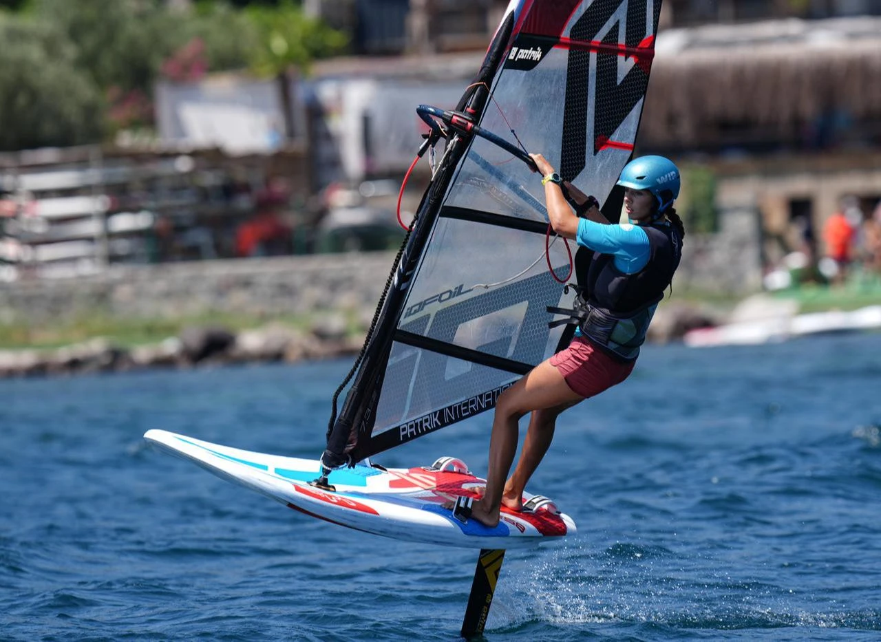 Parla Kabasakal, who won the world championship in the under-17 girls’ windsurfing category at the 2026 IQFOIL Youth and Junior World Championships held in Spain, surfing under the sun. (AA Photo)