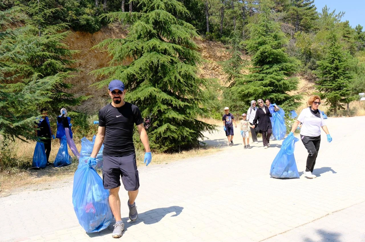 Volunteers cleaning up by collecting glass and bottle waste to help prevent forest fires. (AA Photo)