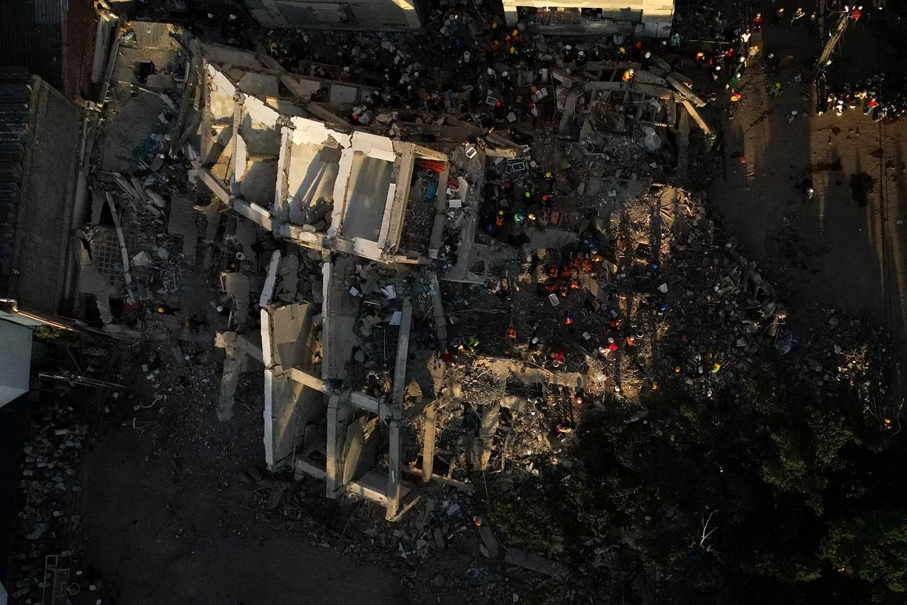 Rescue workers and volunteers gather amid the ruins of collapsed buildings as search operations continue following the earthquake in Pereira, Colombia, Aug. 14, 2026. (AFP Photo)