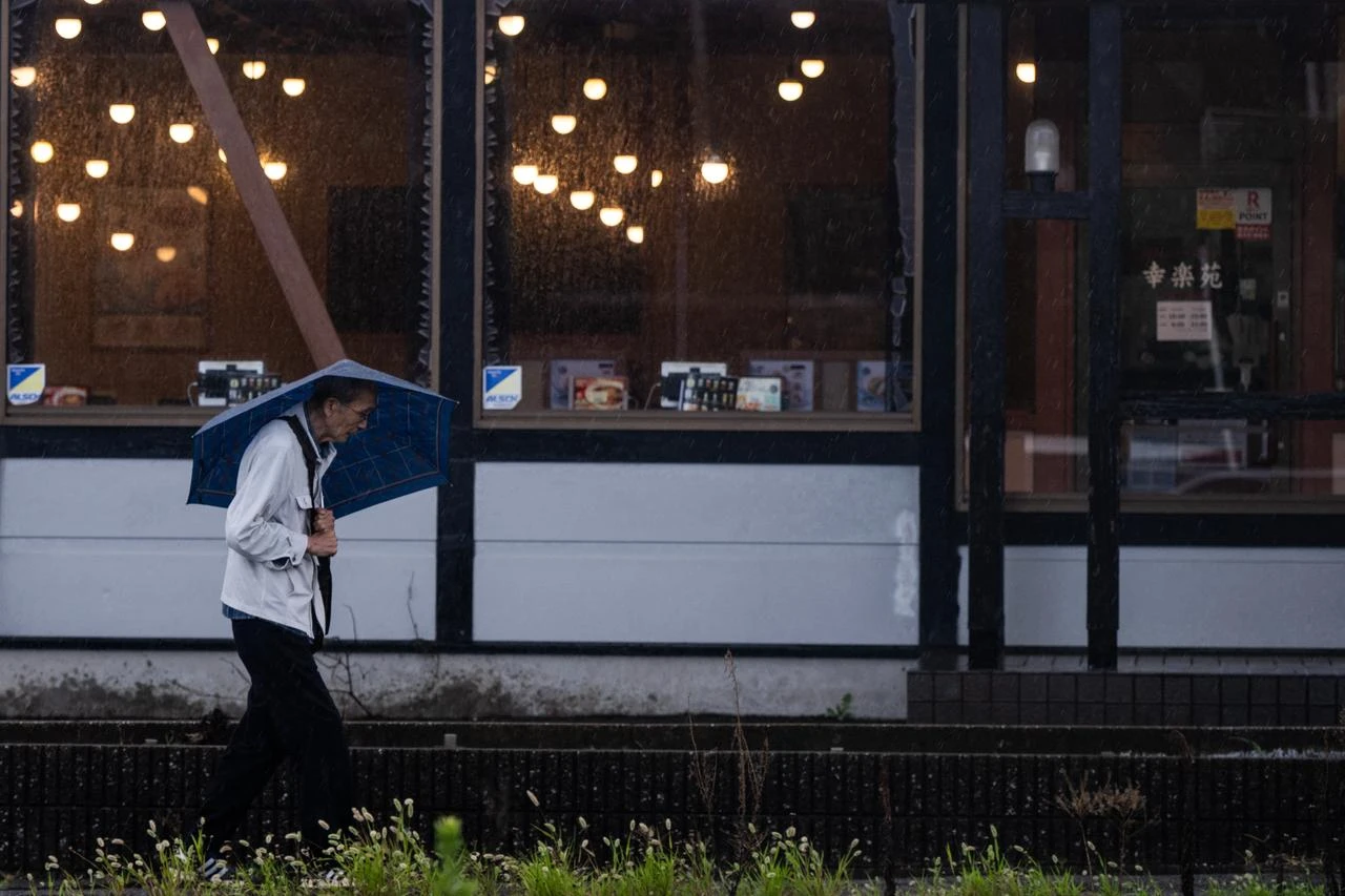 A man walks with an umbrella during heavy rain in Japan, Aug. 14, 2026. (AFP Photo)