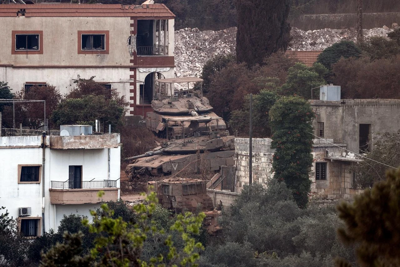 This picture taken from the southern Lebanese village of Zawtar al-Gharbiyah shows Israeli tanks stationed between houses in the nearby village of Zawtar al-Charkiyah on August 13, 2026. (AFP Photo)