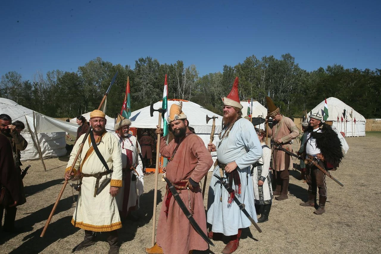 Participants wearing traditional costumes and carrying historical-style weapons pose during the Great Hun-Turkic Kurultaj in Bugac, Hungary. (AA Photo)