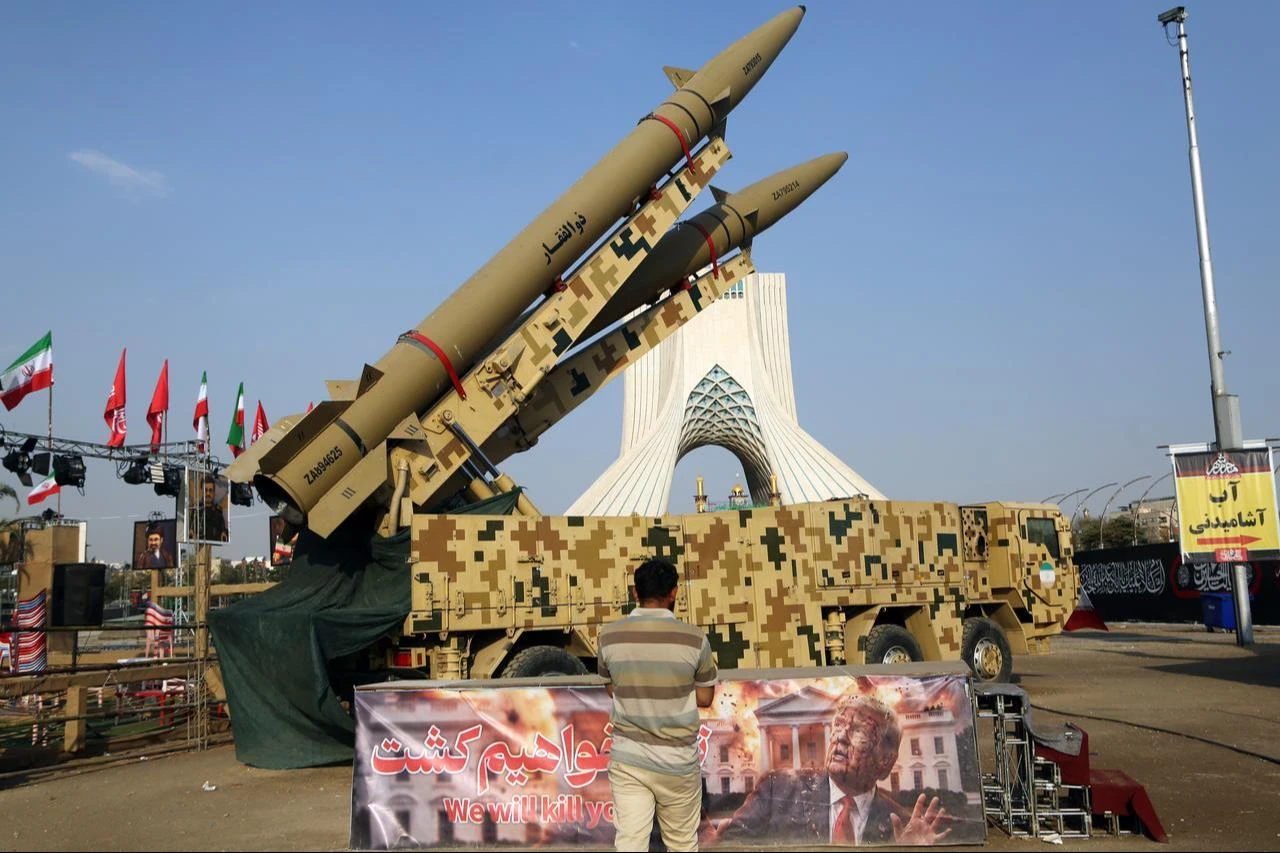 A man looks at a banner depicting U.S. President Donald Trump and bearing messages that were displayed in front of the Zolfaghar and Zolghadr ballistic missiles exhibited at Azadi Square in Tehran, Aug. 2, 2026. (AA Photo)