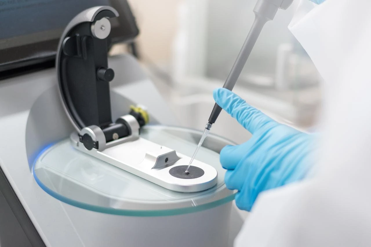 A laboratory researcher uses a pipette to analyze a sample during scientific testing. (Adobe Stock Photo)