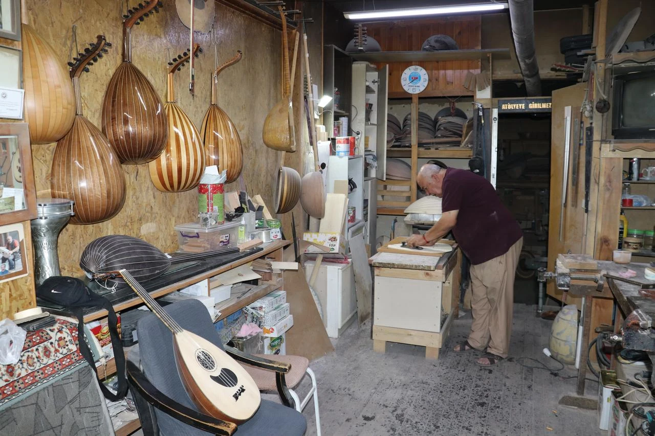 An oud maker works inside his workshop, where handcrafted ouds and instrument parts are displayed, in Sivas, Türkiye, Aug. 15, 2026. (AA Photo)