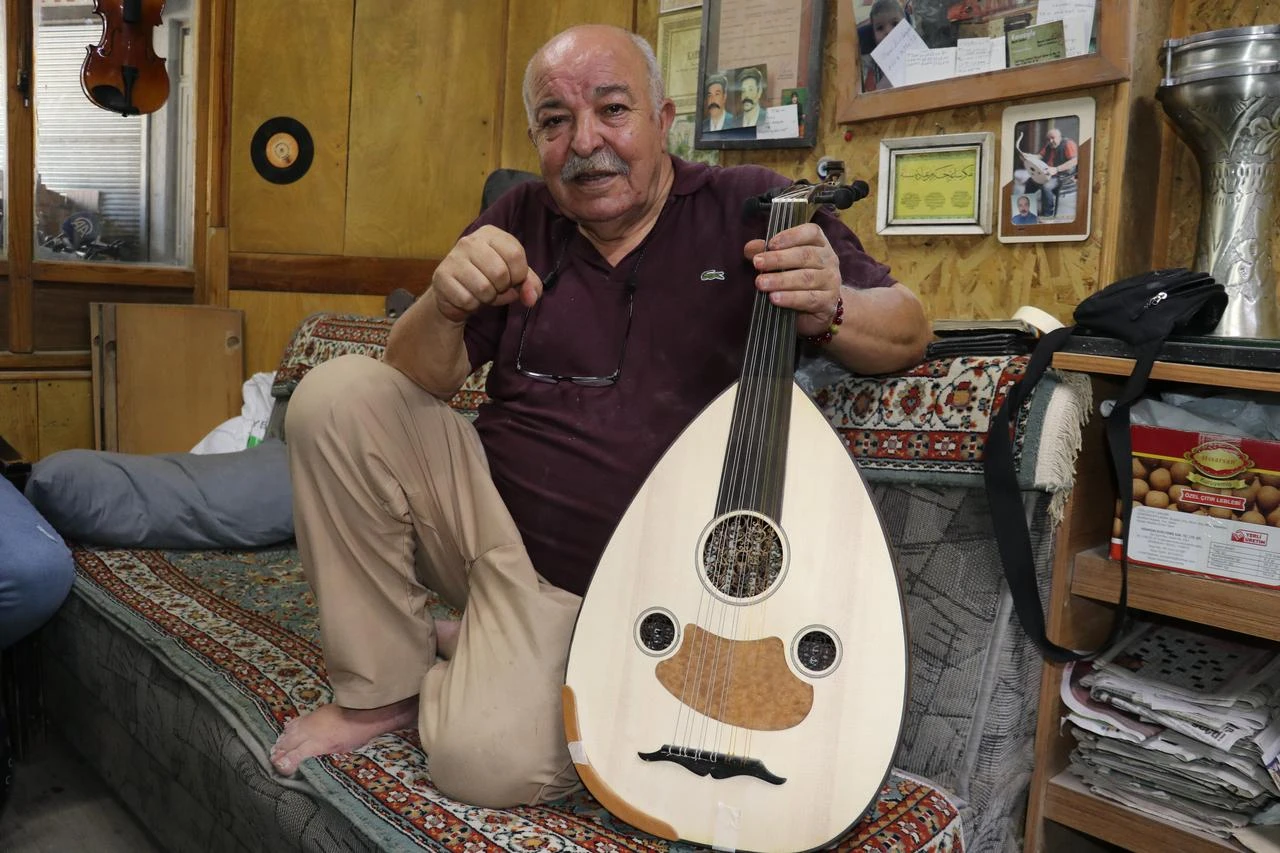An oud maker displays a handcrafted oud at his workshop in Sivas, Türkiye, Aug. 15, 2026. (AA Photo)
