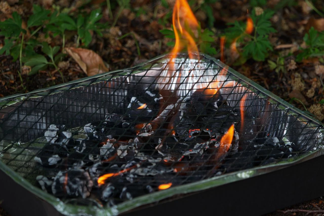 Charcoal burns in an outdoor barbecue grill, illustrating fire risks during hot and dry conditions. (Adobe Stock Photo)