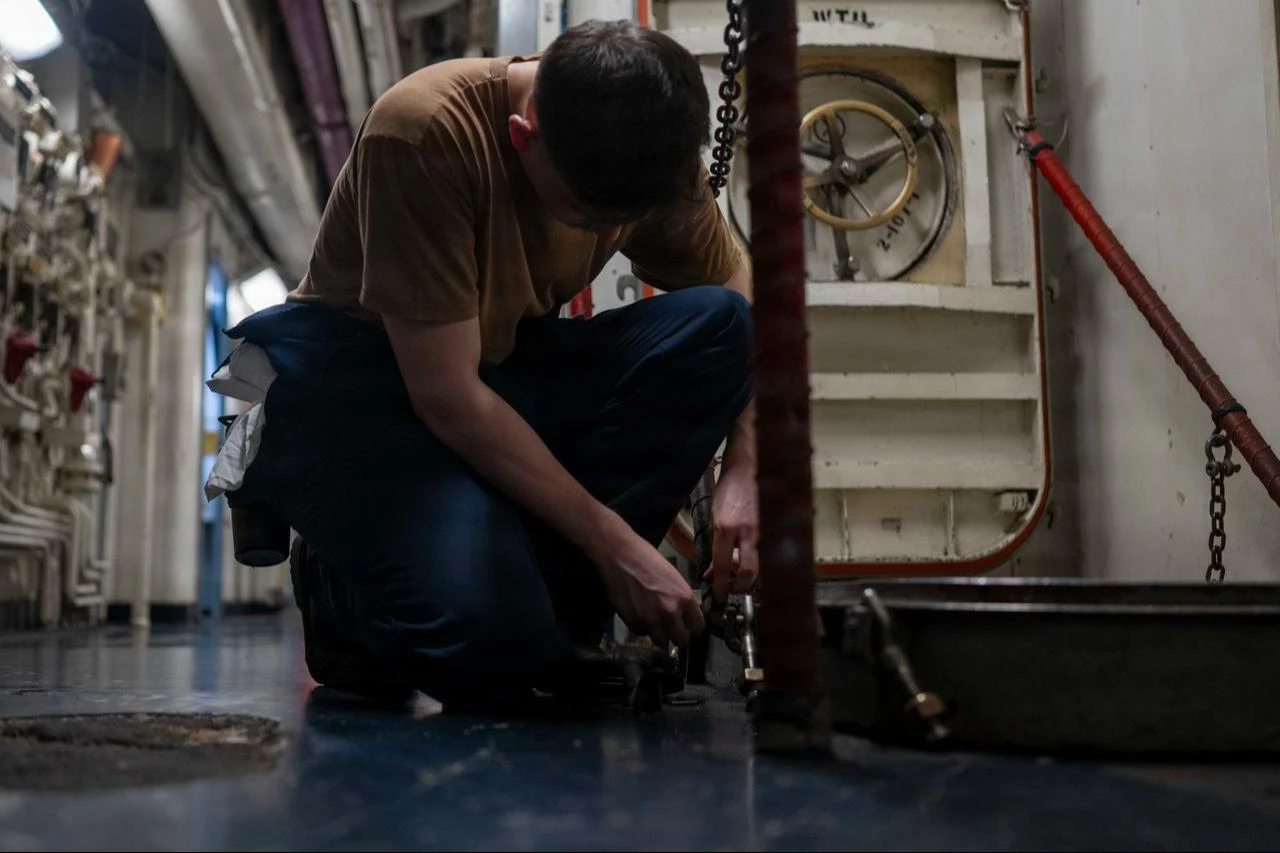 A U.S. Sailor conducts maintenance on a hatch aboard Nimitz-class aircraft carrier USS Abraham Lincoln (CVN 72), Aug. 10, 2026. (Photo via U.S. Navy)