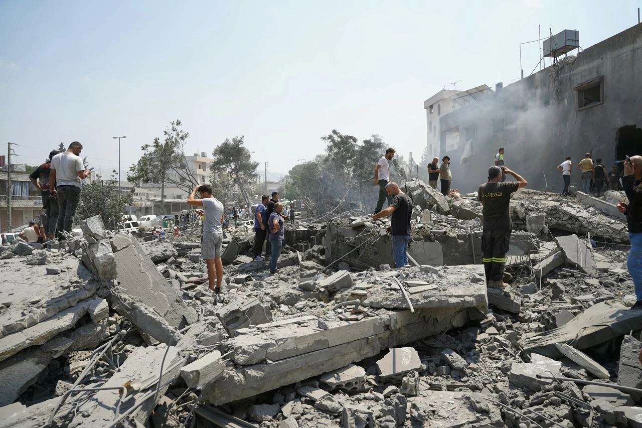First aid responders and residents rush to the site of an Israeli airstrike that targeted the neighborhood in the southern Lebanese village of Deir al-Zahrani on August 15 2026. (AFP Photo)