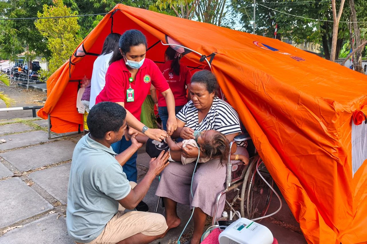 A young patient is treated next to a temporary medical tent set up due to fears of aftershocks in Maumere on Flores Island on August 15, 2026. (AFP Photo)