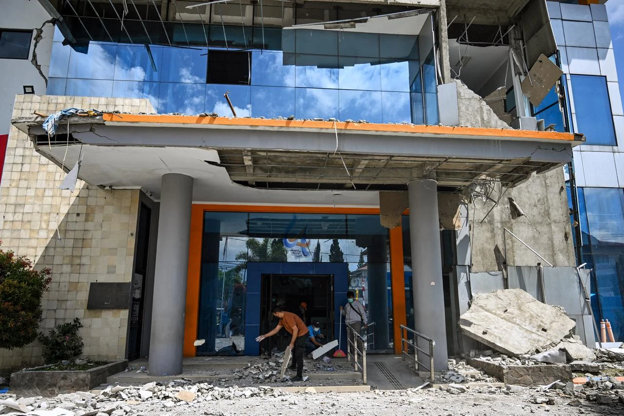 A employees clears debris from a damaged bank building following a 7.7-magnitude earthquake in Ruteng, Manggarai, East Nusa Tenggara on August 16, 2026. (AFP Photo)