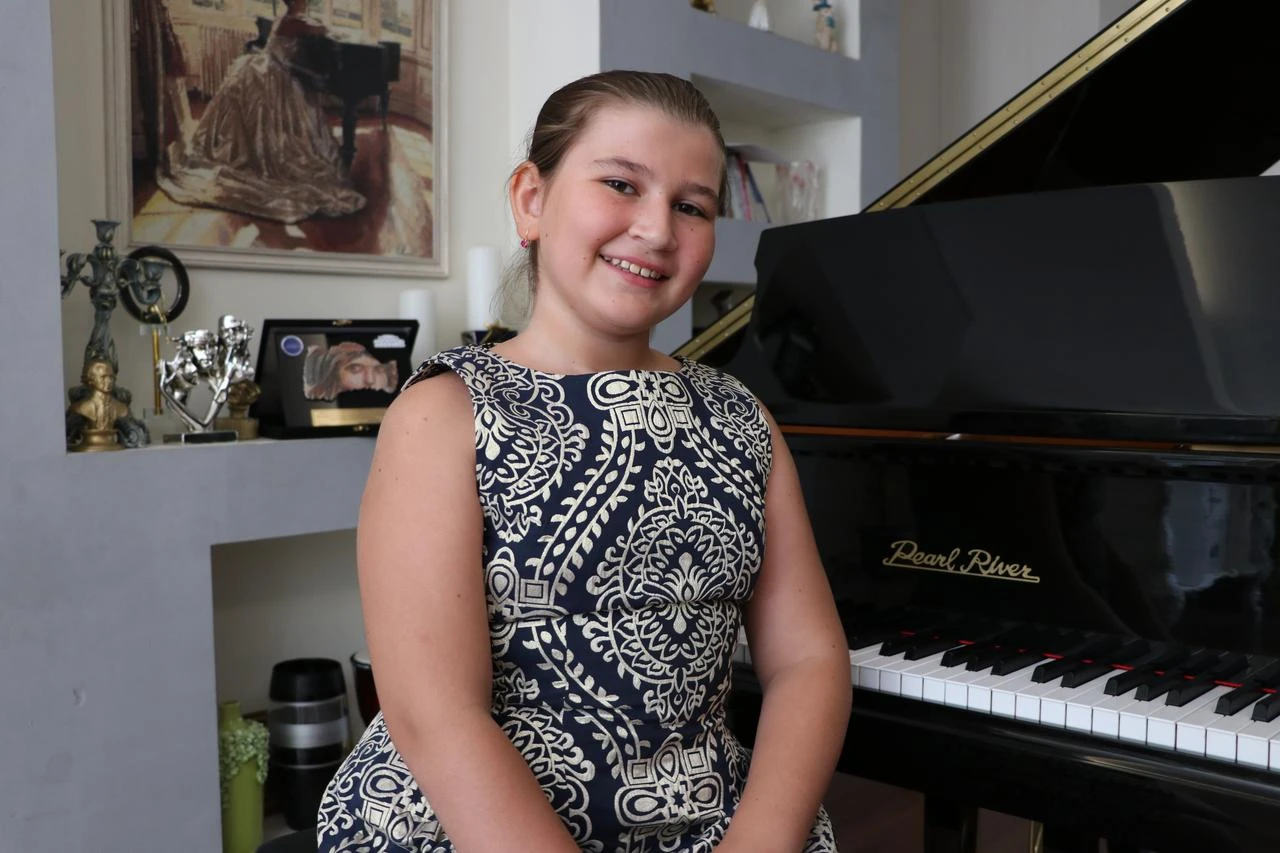 11-year-old Elif Anastasia Cavdar posing next to piano. (AA Photo)