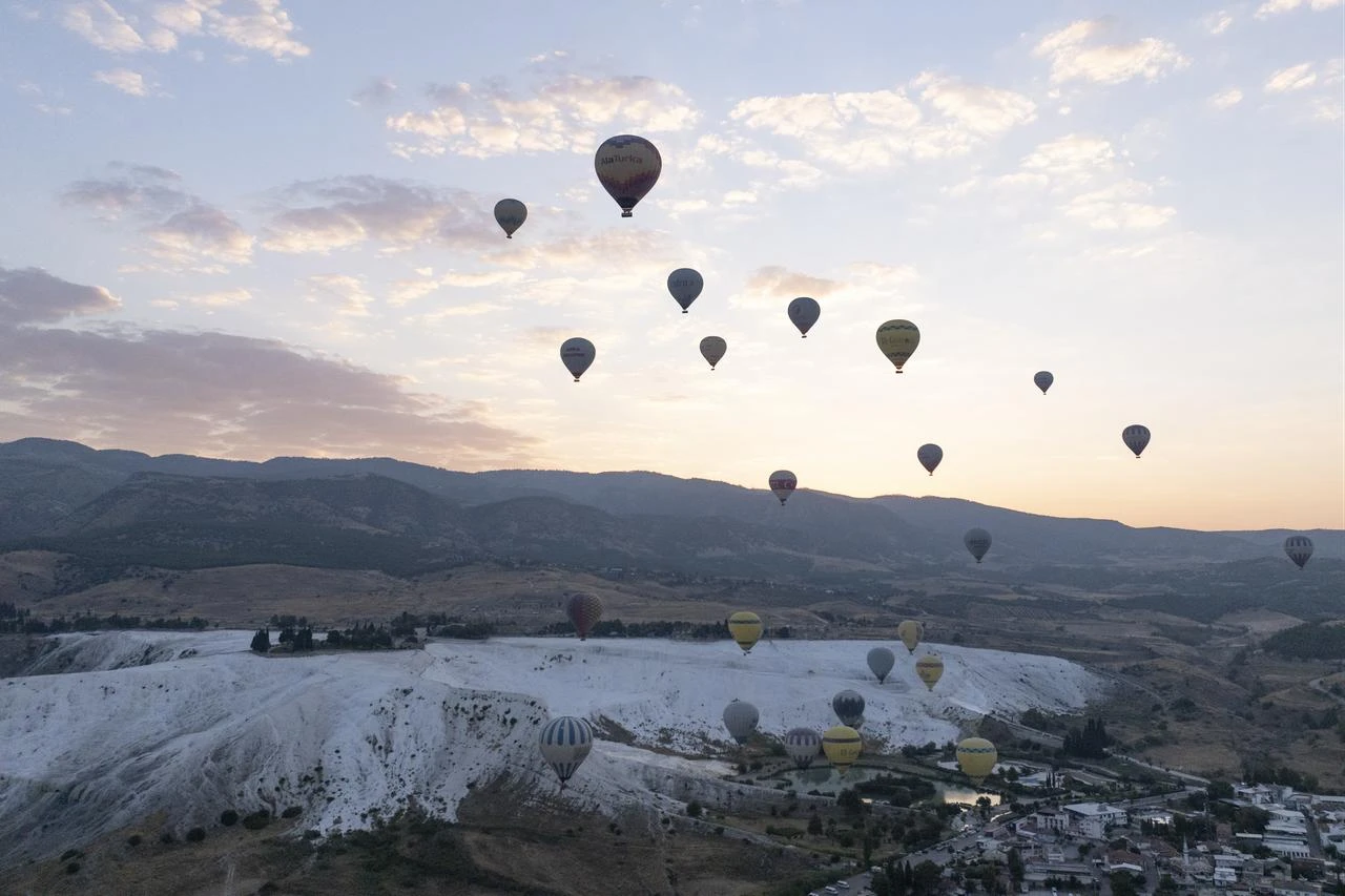 A view shows hot air balloons flying at sunrise over Pamukkale in Denizli, Türkiye, Aug. 13, 2026. (AA Photo)