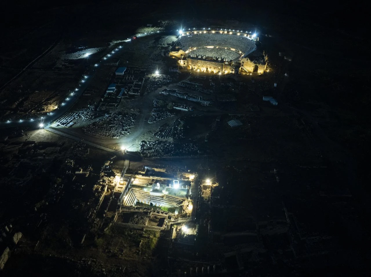 An aerial view shows the illuminated ancient theater and surrounding ruins of Hierapolis during night museum hours in Pamukkale, Denizli, Türkiye, Aug. 13, 2026. (AA Photo)