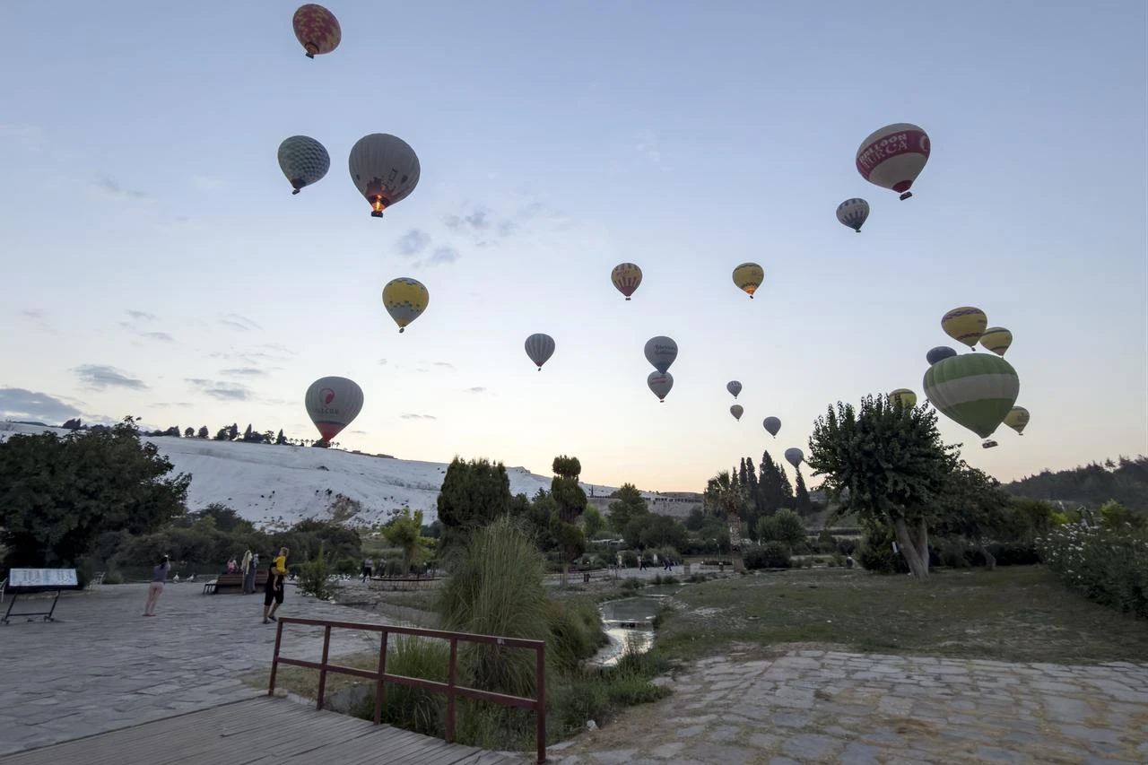 Hot air balloons fly over the UNESCO World Heritage site of Pamukkale and the ancient city of Hierapolis during sunrise in Denizli, Türkiye, Aug. 13, 2026. (AA Photo)