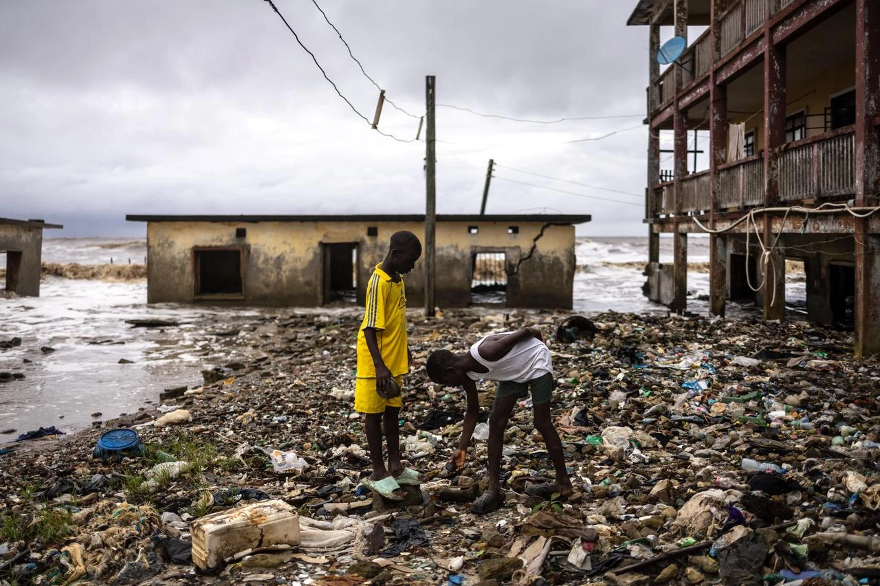Children inspect debris washed ashore by the sea at the King's Palace, damaged by coastal erosion in Ayetoro, Ondo State, on August 7, 2026. (AFP Photo)