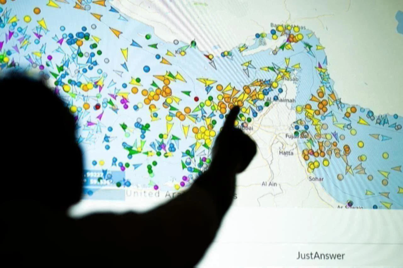 A photo illustration taken in Lefkosia on May 4, 2026, shows a person in front of a large screen displaying vessel movements in the Strait of Hormuz on a ship-tracking website. (AFP Photo)