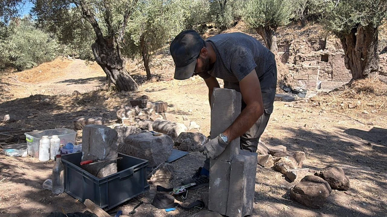 A member of the excavation team works among architectural remains uncovered at the ancient city of Antandros in Balikesir, western Türkiye. (IHA Photo)